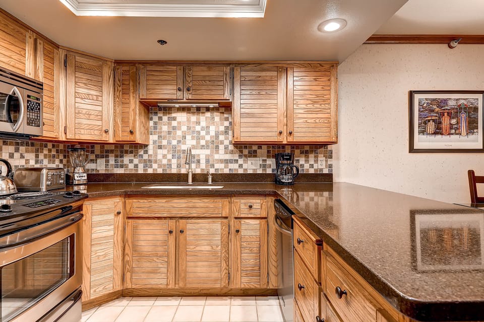 The well-equipped kitchen offers stainless steel appliances and wood cabinets.