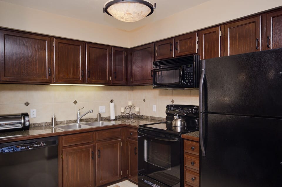 Your fully equipped kitchen features rich wood cabinetry, granite countertops, and modern appliances for preparing memorable meals during your stay.