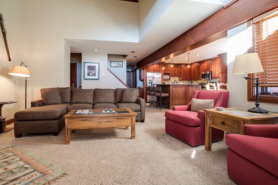 Relax in your spacious living area with plush seating and open kitchen, perfect for unwinding after mountain adventures.