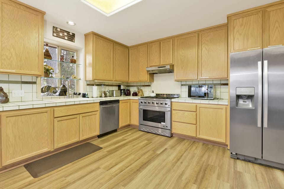 Fully equipped cabin kitchen with beautiful wood cabinets, stove, fridge, microwave, and coffee maker—perfect for cooking meals, morning coffee, and feeling right at home on your stay.
