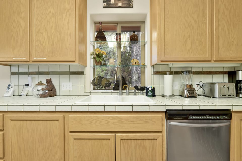 Fully equipped cabin kitchen with beautiful wood cabinets, stove, fridge, microwave, and coffee maker—perfect for cooking meals, morning coffee, and feeling right at home on your stay.