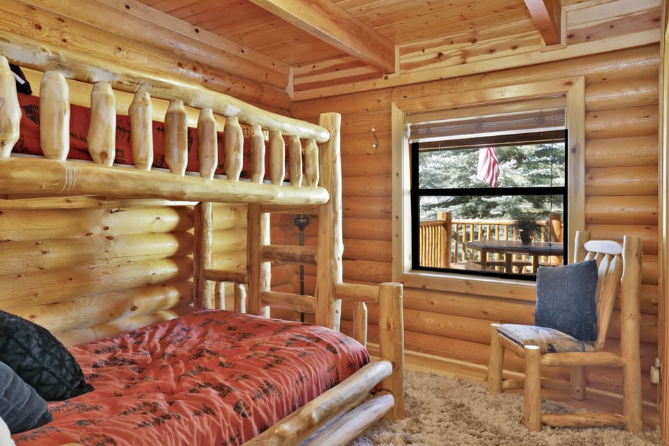 Peaceful cabin bedroom with plush bedding, and beautiful views—ideal for restful nights, cozy mornings, and a relaxing mountain escape.