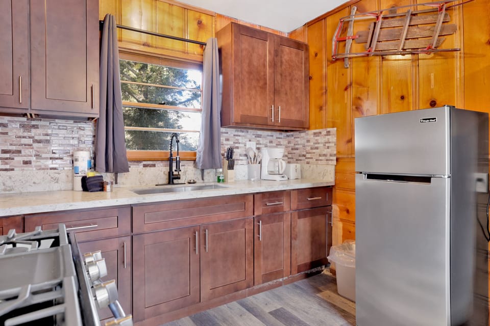 Kitchen with a refrigerator, stove, microwave, oven, and a coffee machine.