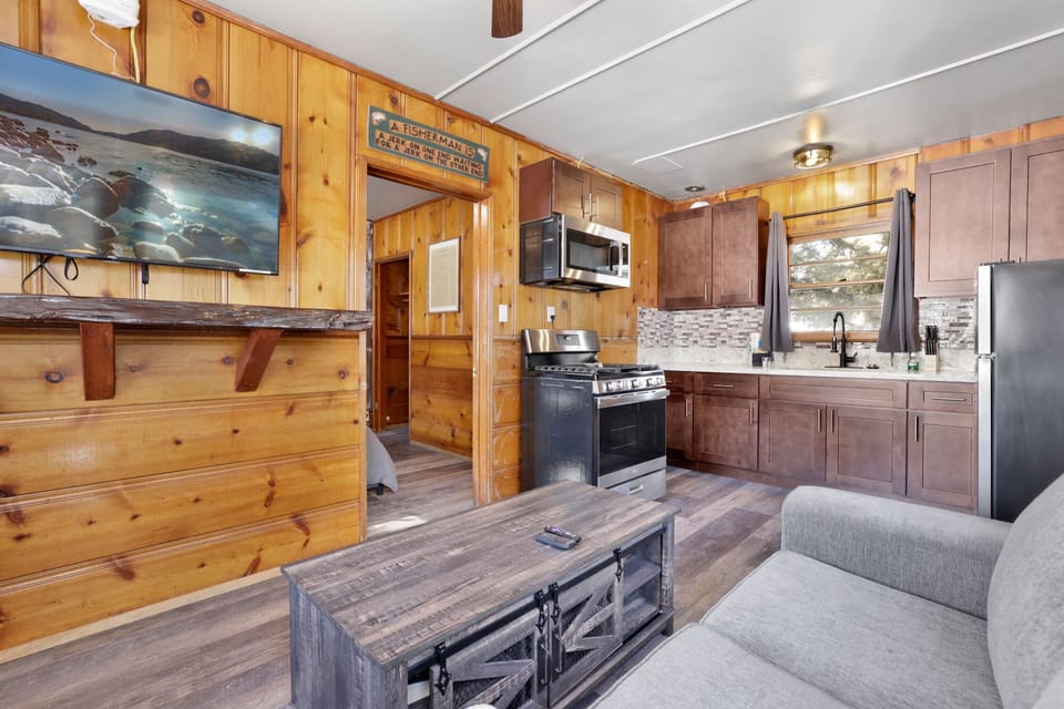 Cozy cabin living room with a comfy seating, and rustic wood details—perfect for relaxing evenings, movie nights, and unforgettable mountain getaways.