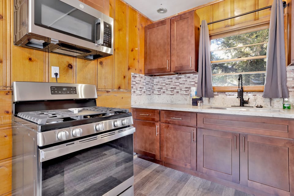 Kitchen with a refrigerator, stove, microwave, oven, and a coffee machine.