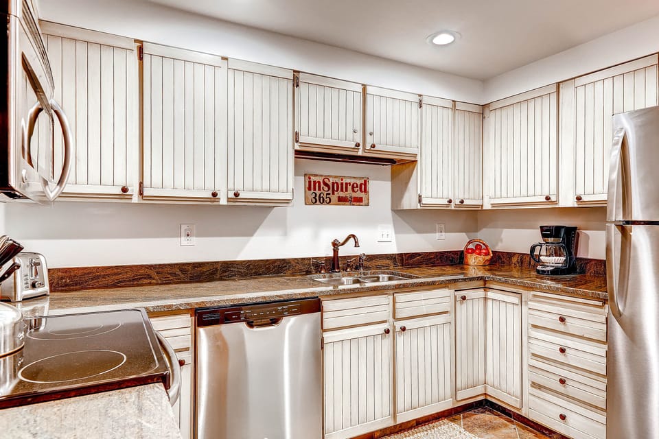 Park Station 134's kitchen with white cabinets, recessed lighting, and stainless steal appliances.
