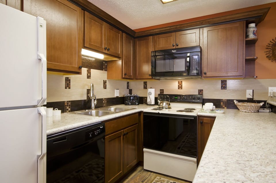Your fully equipped kitchen awaits with granite countertops, rich wood cabinets, and modern appliances to create memorable meals during your stay.