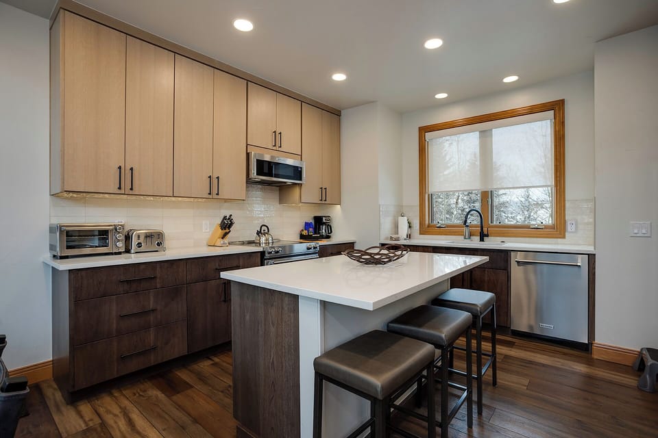 Your modern kitchen features sleek two-tone cabinets, granite countertops, and stainless steel appliances, perfect for preparing meals during your stay.
