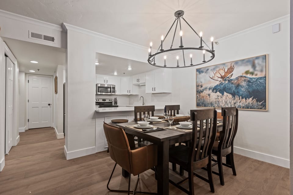 The dining table has 6 chairs, beautiful chandelier and moose artwork.