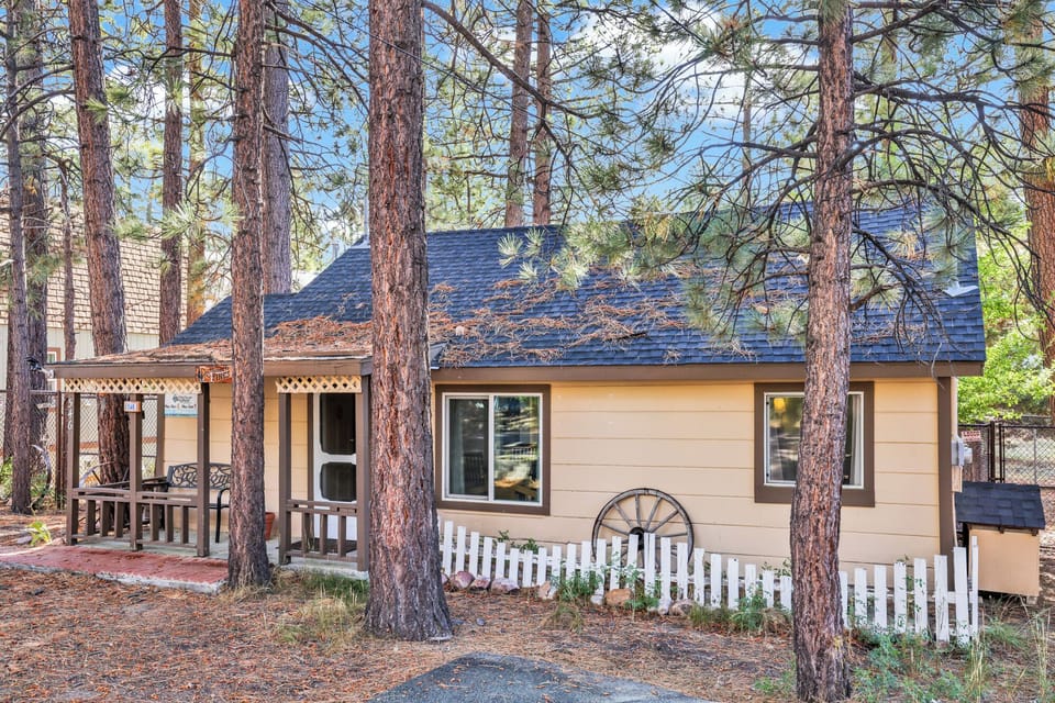 Welcoming cabin entry surrounded by towering pine trees, offering fresh mountain air and a peaceful forest setting—the perfect first impression for your Big Bear Lake getaway.