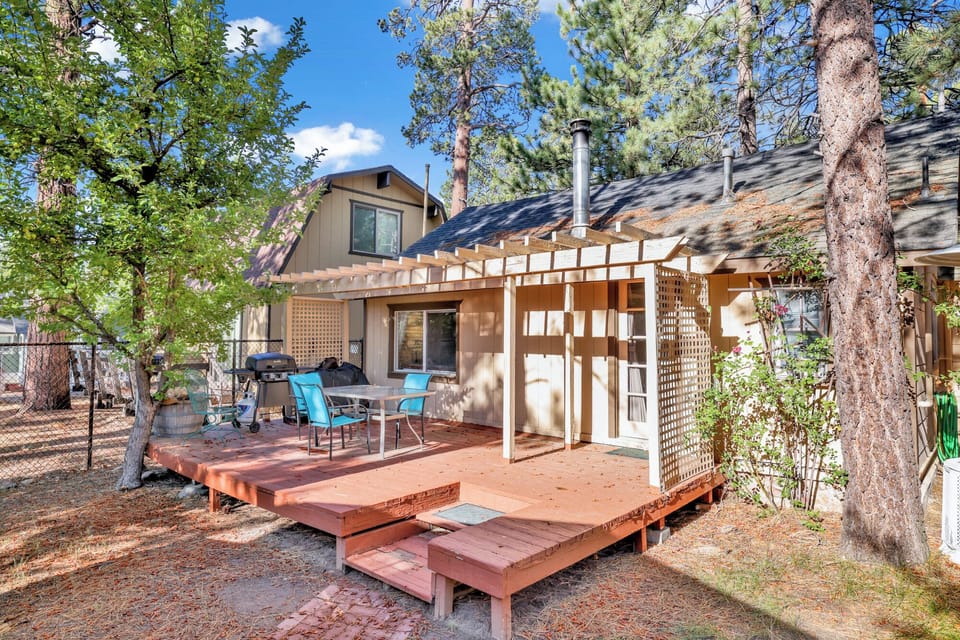 Private outdoor backyard with a BBQ, surrounded by tall pines, perfect for relaxing under the trees after a day of adventure—enjoy peaceful forest views, fresh air, and a truly rejuvenating stay.