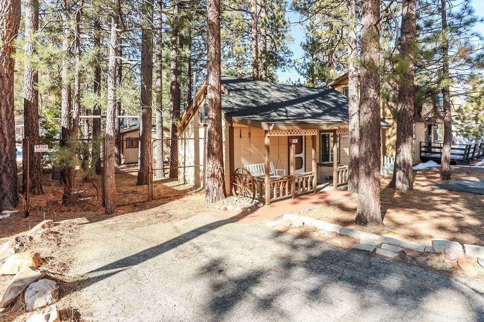 Welcoming cabin entry surrounded by towering pine trees, offering fresh mountain air and a peaceful forest setting—the perfect first impression for your Big Bear Lake getaway.
