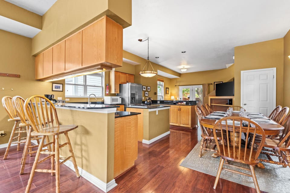 The U-shape kitchen has a center island, a breakfast bar on one side and is open to the dining table.