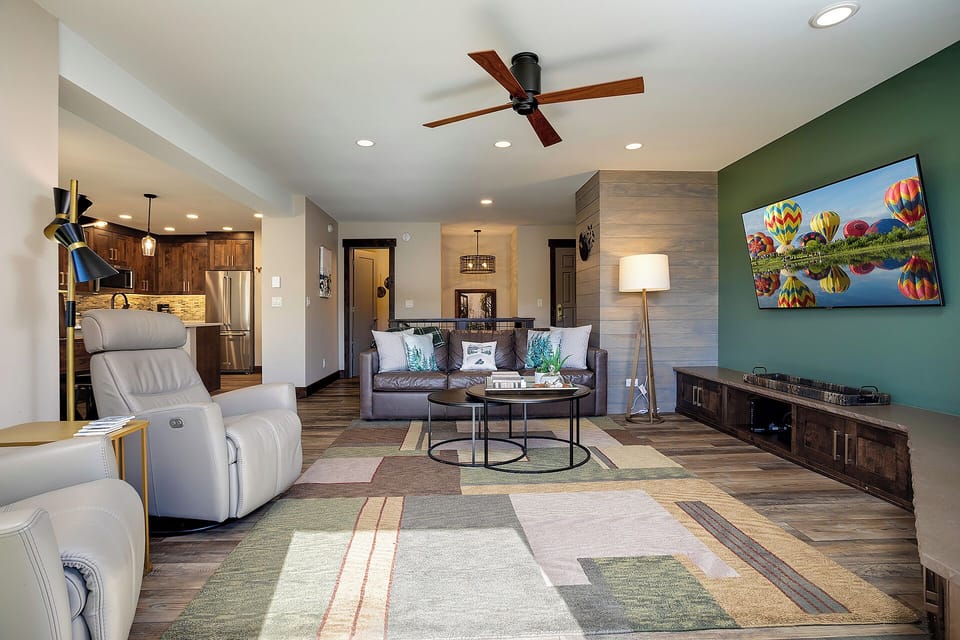 Relax in your spacious living room with modern furnishings, vibrant artwork, and an open kitchen perfect for entertaining.