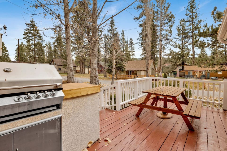 Private cabin deck with BBQ grill and picnic table, perfect for outdoor dining, grilling, and relaxing among tall pines—ideal for cozy mountain stays and memorable Airbnb getaways.
