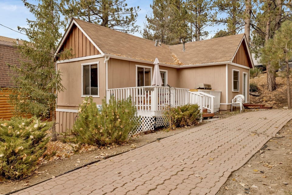 Private cabin deck with BBQ grill and picnic table, perfect for outdoor dining, grilling, and relaxing among tall pines—ideal for cozy mountain stays and memorable Airbnb getaways.