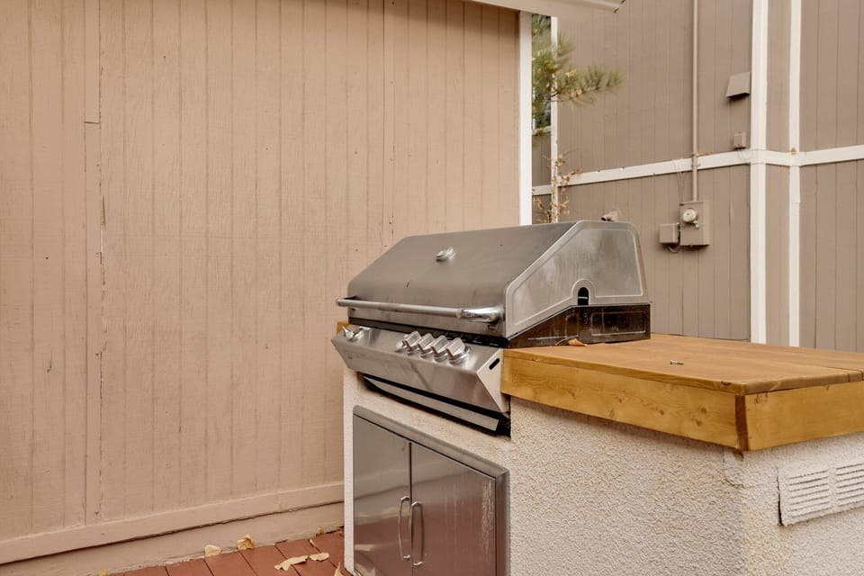 Private cabin deck with BBQ grill and picnic table, perfect for outdoor dining, grilling, and relaxing among tall pines—ideal for cozy mountain stays and memorable Airbnb getaways.