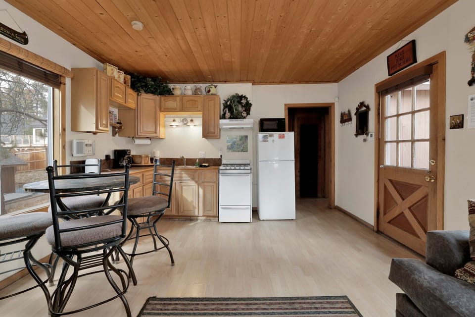 Fully equipped cabin kitchen with warm wood cabinets, gas stove, fridge, microwave, and coffee maker—perfect for cooking meals, morning coffee, and feeling right at home on your Airbnb stay.