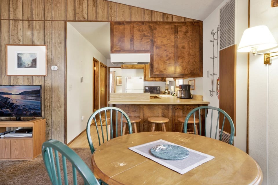 Enjoy meals together at the wooden dining table or the cozy breakfast bar with stool seating.