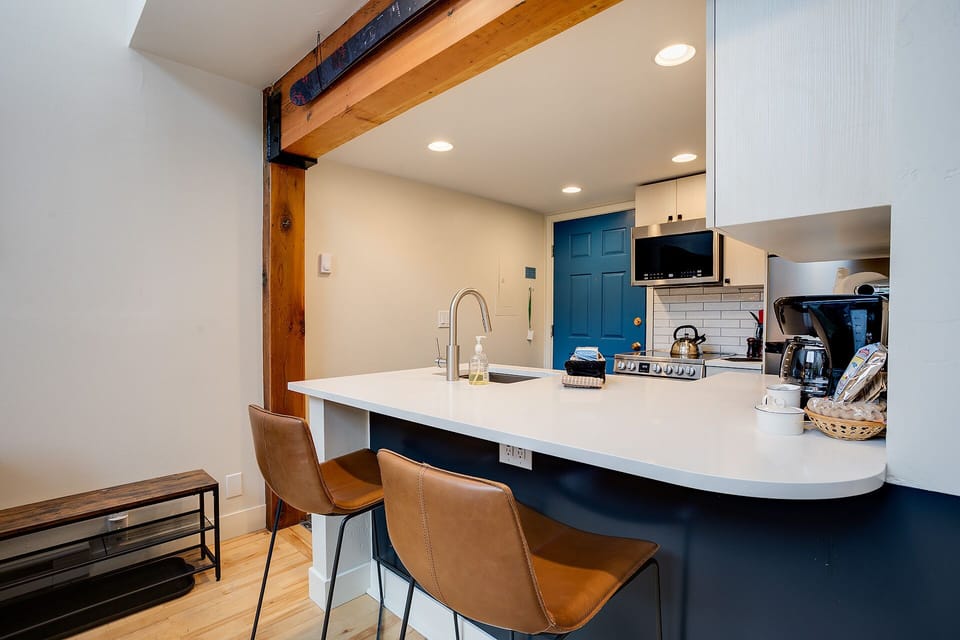 Gather around your modern kitchen island with stylish bar seating, where exposed beams meet sleek countertops for memorable meal prep and conversations.