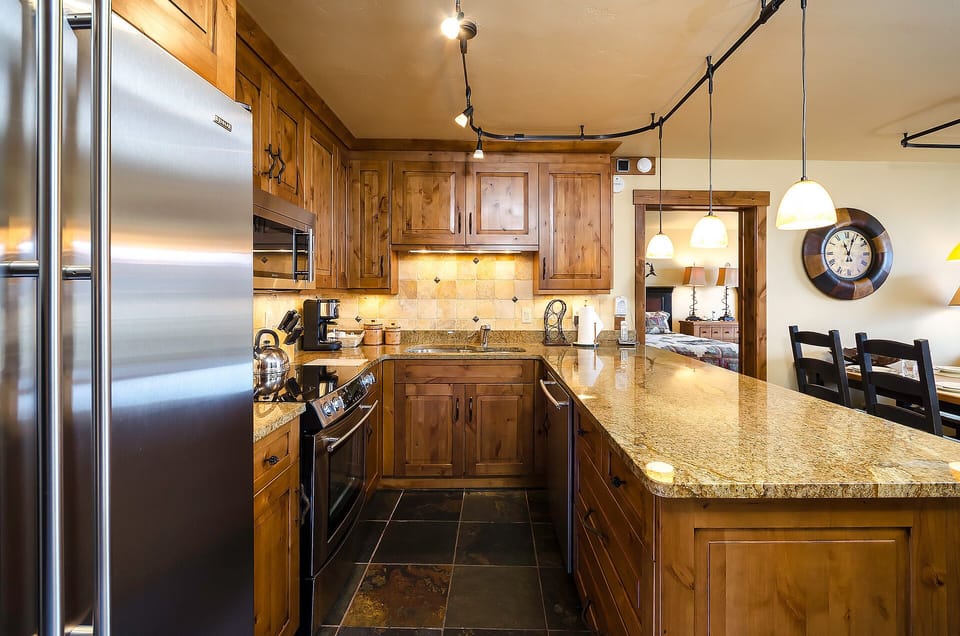 Your gourmet kitchen awaits with rich wood cabinetry, granite counters, and stainless steel appliances—perfect for creating memorable meals together.