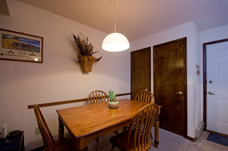 Gather around your warm wooden dining table under soft pendant lighting for memorable meals together.