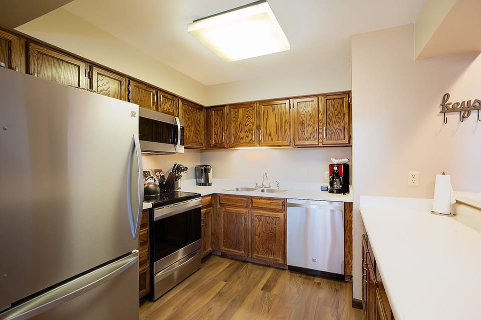 Your fully equipped kitchen features stainless steel appliances and warm wood cabinetry, perfect for preparing home-cooked meals during your stay.