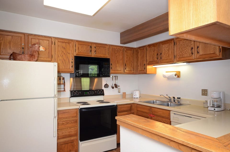 Your fully equipped kitchen features warm wood cabinets, modern appliances, and a charming skylight that fills the space with natural light.