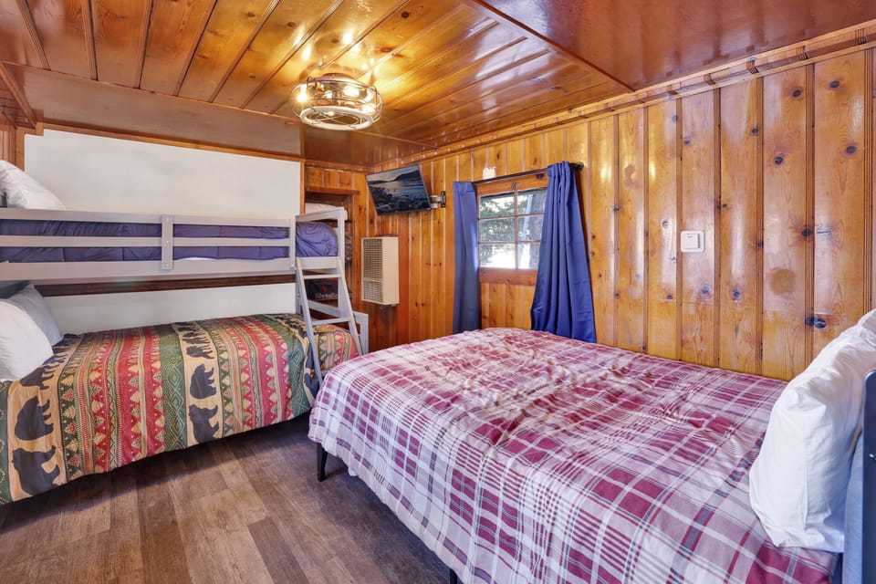 A full bunk bed and a full size bed with a TV to enjoy a movie night.