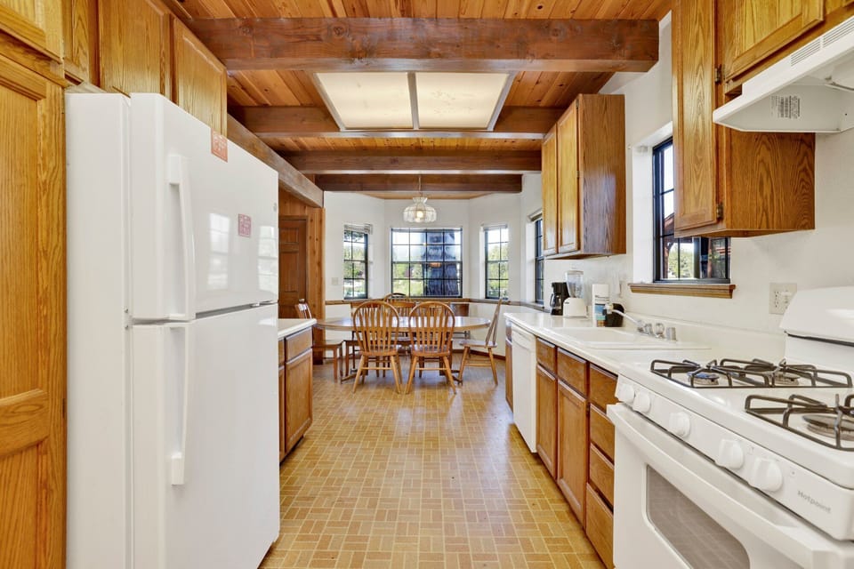 Fully equipped cabin kitchen with warm wood cabinets,stove, fridge, microwave, and coffee maker—perfect for cooking meals, morning coffee, and feeling right at home on your stay.