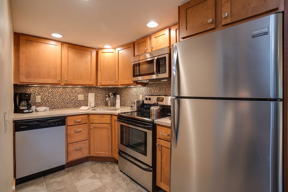 Your fully equipped kitchen features stainless steel appliances and warm wood cabinets, perfect for preparing meals during your stay.