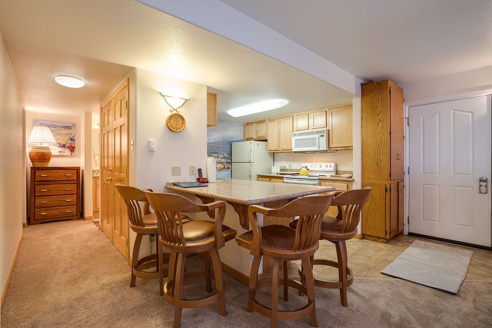 Your fully equipped kitchen and breakfast bar invite leisurely mornings and easy meal prep, with warm wood finishes creating a cozy home-away-from-home feeling.
