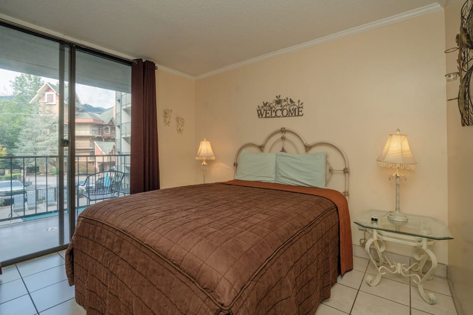 Your peaceful bedroom retreat features warm lighting and opens to a private balcony where you can unwind with views of the surrounding neighborhood.