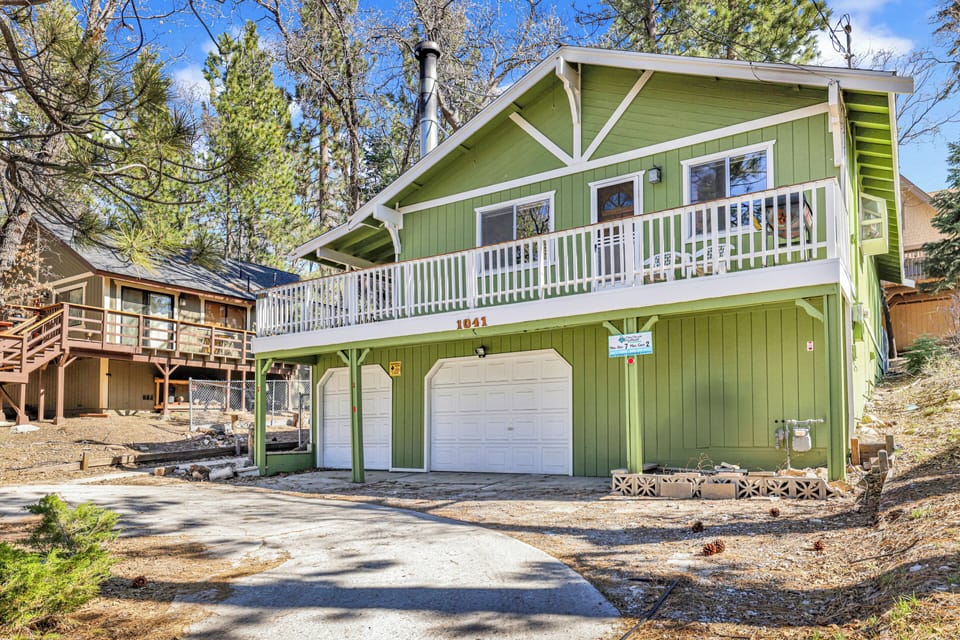 Welcoming cabin entry surrounded by towering pine trees, offering fresh mountain air and a peaceful forest setting—the perfect first impression for your Big Bear Lake getaway.