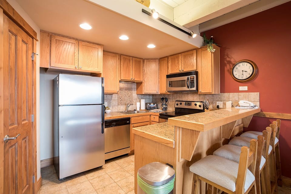 Cook your favorite meals in this fully-equipped kitchen featuring stainless steel appliances, granite counters, and cozy breakfast bar seating.