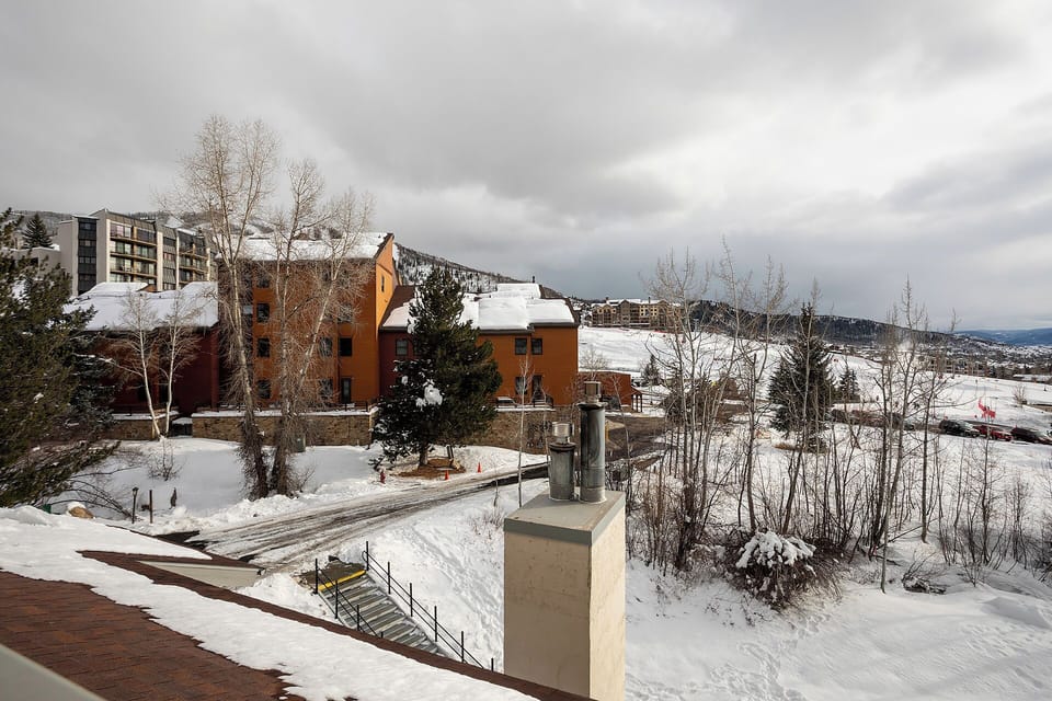 Winter mountain resort setting with snow-covered grounds and distinctive orange-colored buildings nestled in the alpine landscape.