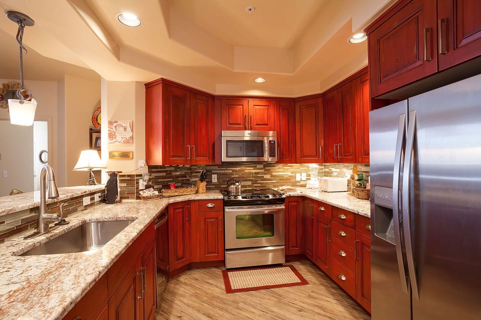 Your fully equipped gourmet kitchen features rich cherry cabinets, granite counters, and stainless steel appliances—perfect for preparing memorable meals during your stay.