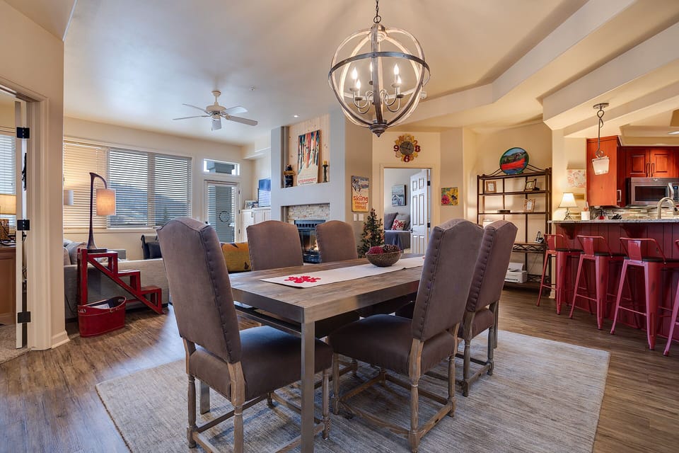 Gather around your elegant dining table where memorable meals unfold beneath warm pendant lighting and exposed beams.