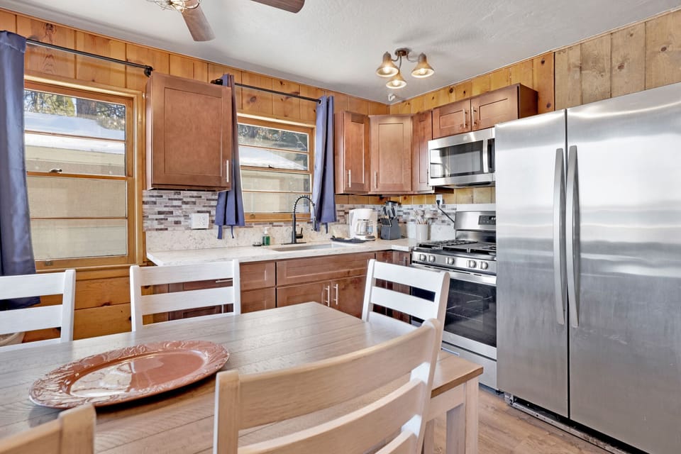 Kitchen with a refrigerator, stove, microwave, oven,coffee machine, and a dining table to enjoy a delicious meal.