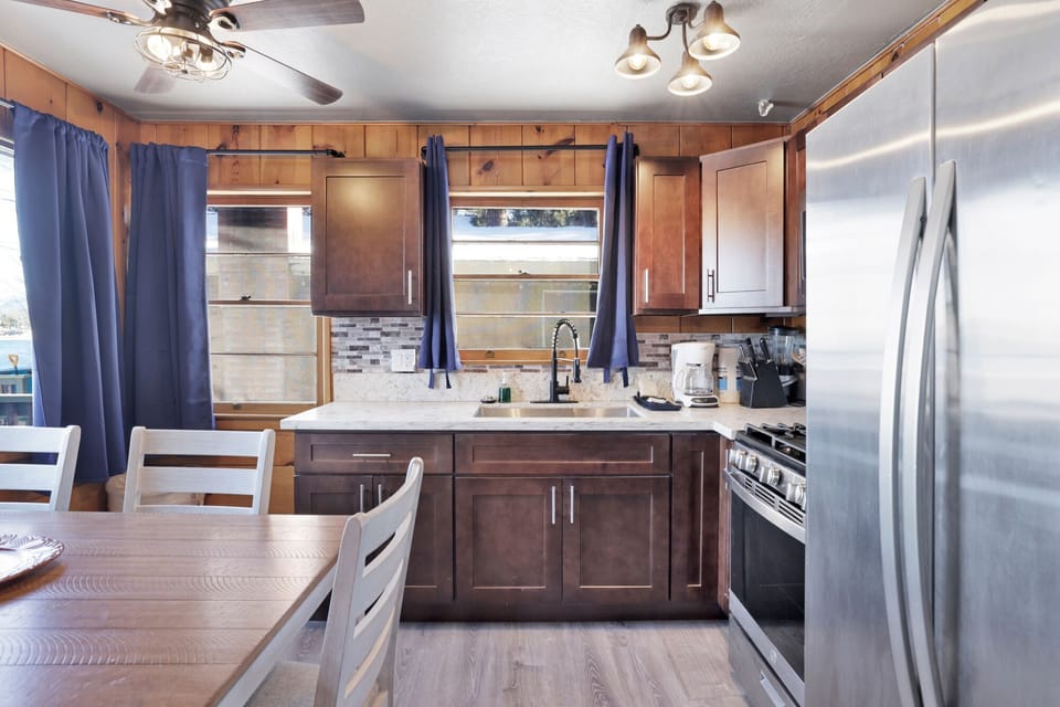 Kitchen with a refrigerator, stove, microwave, oven,coffee machine, and a dining table to enjoy a delicious meal.