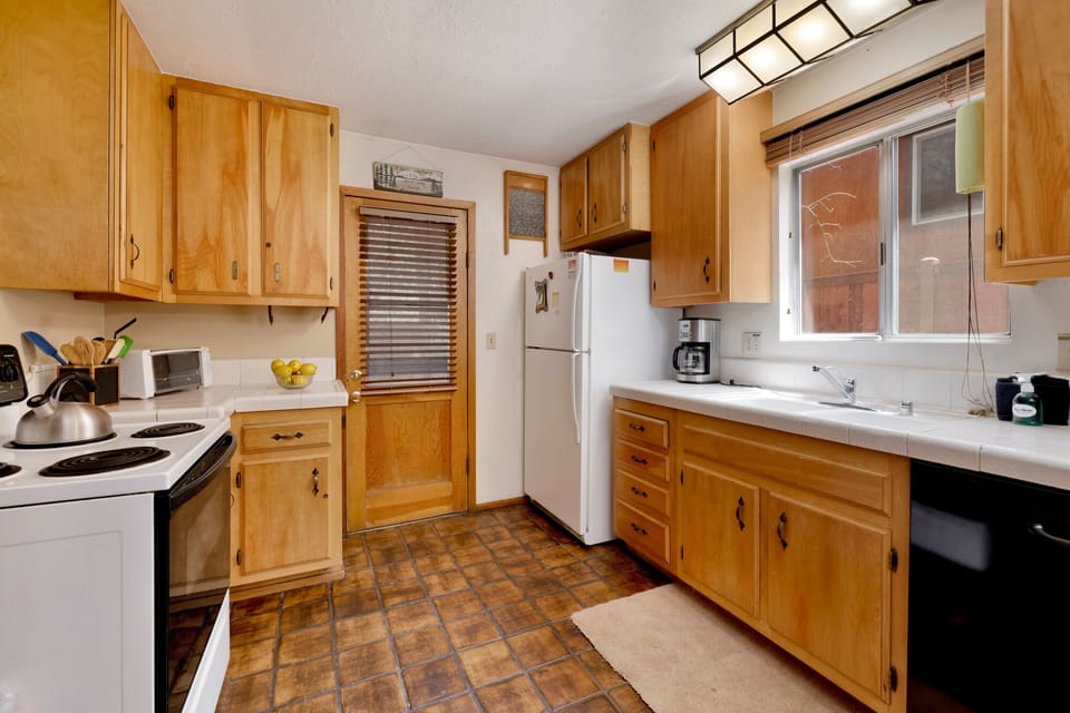 Fully equipped cabin kitchen with ample cabinetry, stove, fridge, microwave, and coffee maker—perfect for cooking meals, morning coffee, and feeling right at home on your stay.