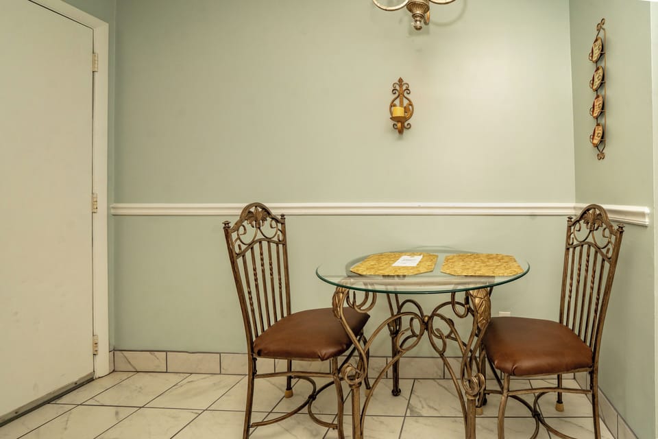 A cozy breakfast nook with elegant wrought-iron furniture and soft mint walls creates your perfect morning coffee spot.