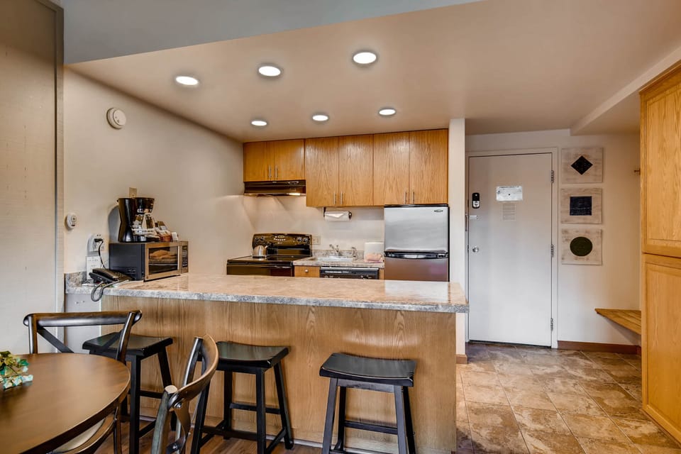 The dining area with seating for 4 guests and the breakfast bar with seating for three guests.