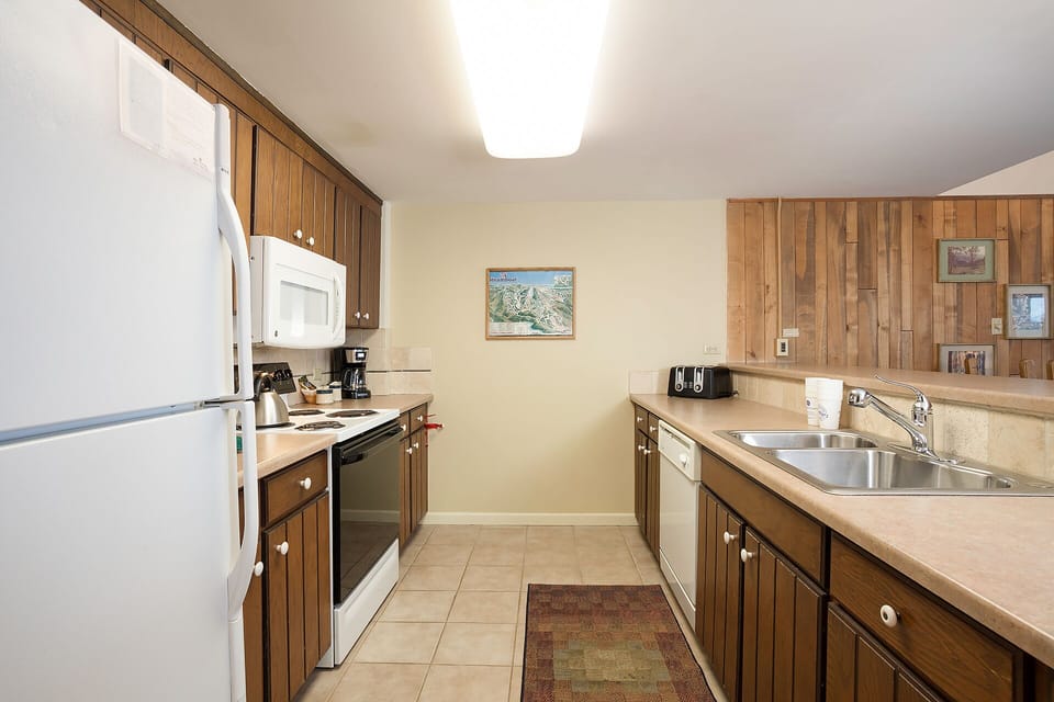 Prepare your favorite meals in this fully equipped kitchen with modern appliances, warm wood cabinetry, and everything you need for a comfortable stay.