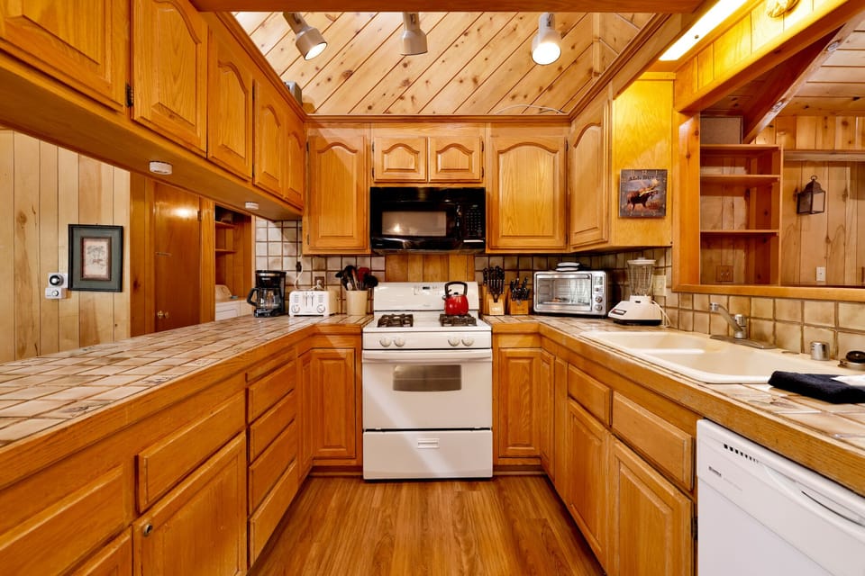 Fully equipped cabin kitchen with ample cabinetry, stove, fridge, microwave, and coffee maker—perfect for cooking meals, morning coffee, and feeling right at home on your stay.