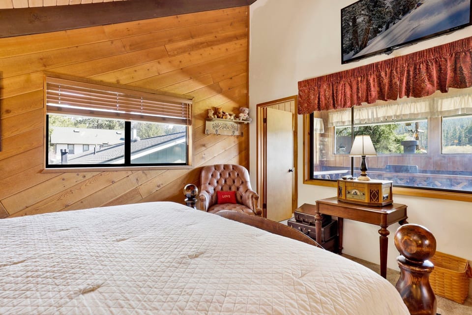 Peaceful cabin bedroom with plush bedding, and beautiful views—ideal for restful nights, cozy mornings, and a relaxing mountain escape.