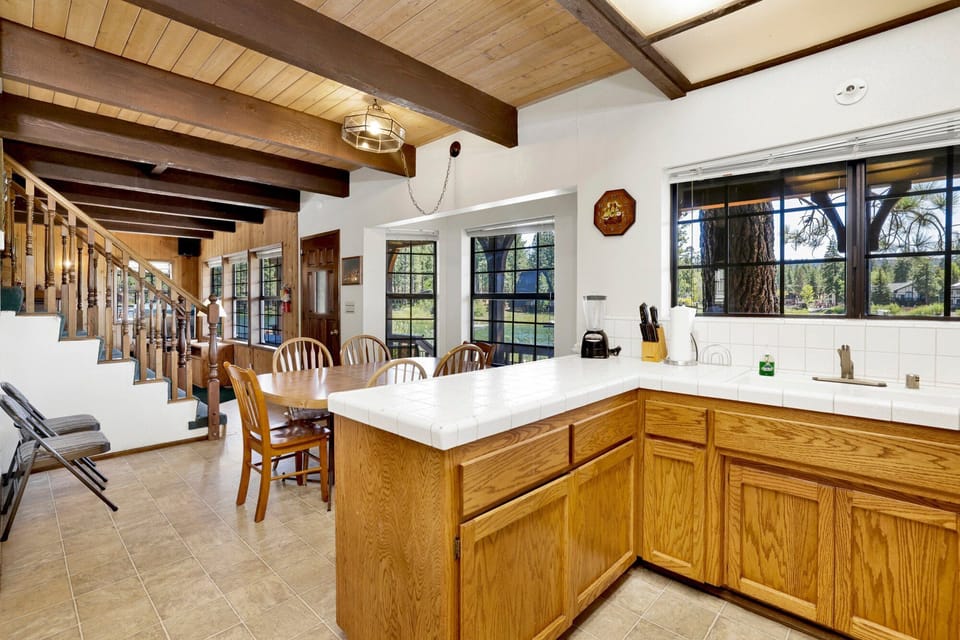 Fully equipped cabin kitchen with warm wood cabinets, stove, fridge, microwave, and coffee maker—perfect for cooking meals, morning coffee, and feeling right at home on your stay.