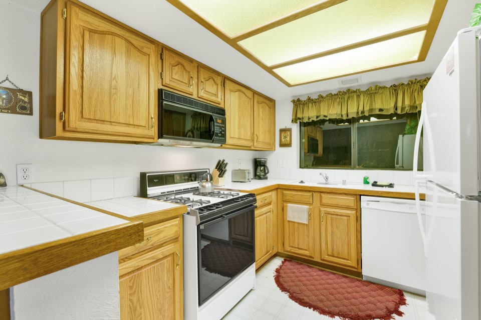 Fully equipped cabin kitchen with ample cabinetry, stove, fridge, microwave, and coffee maker—perfect for cooking meals, morning coffee, and feeling right at home on your stay.