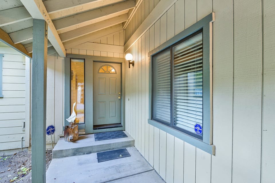 Welcoming cabin entry surrounded by towering pine trees, offering fresh mountain air and a peaceful forest setting—the perfect first impression for your Big Bear Lake getaway.