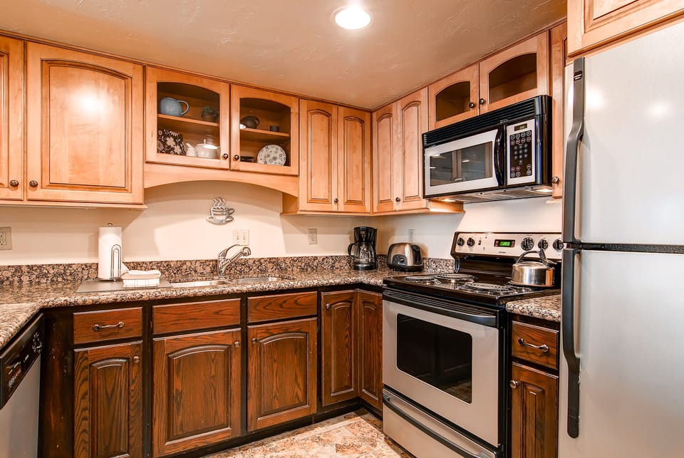 The well-equipped kitchen has wood cabinets and stainless steel appliances.